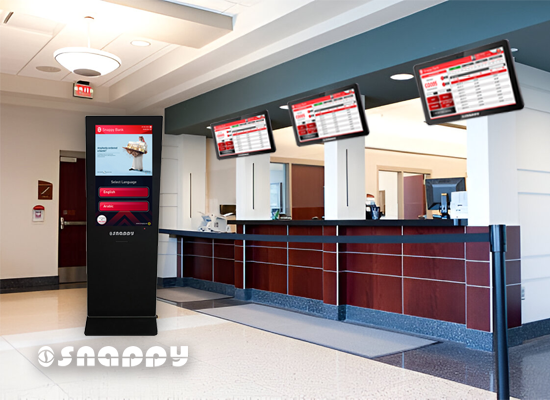 Snappy self-service kiosk with digital queue display screens in a modern service reception area